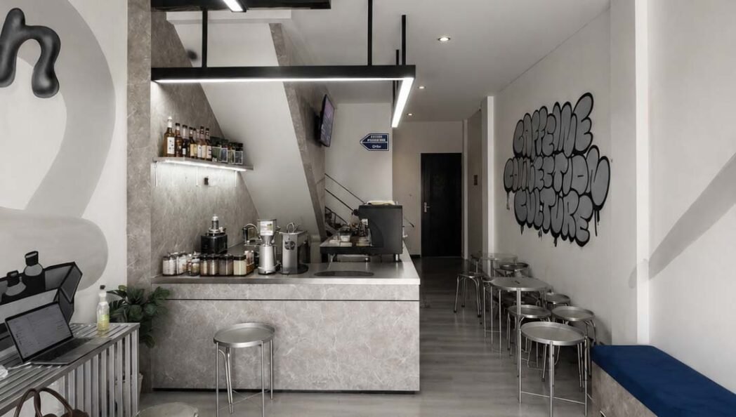 Ascension Café Bintaro is designed as a contemporary café space that combines a clean, minimalist aesthetic with warm and functional details. The interior makes thoughtful use of neutral tones, stone textures, and black accents to create a refined yet approachable atmosphere.